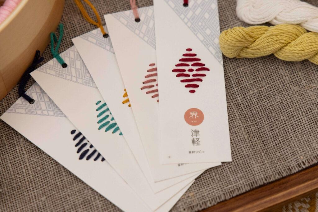 「思い出こぎん」の刺繡糸は全部で8色から選べる。紙製のしおりの穴に糸を刺していけば、簡単にこぎん刺しのプチ体験ができる。